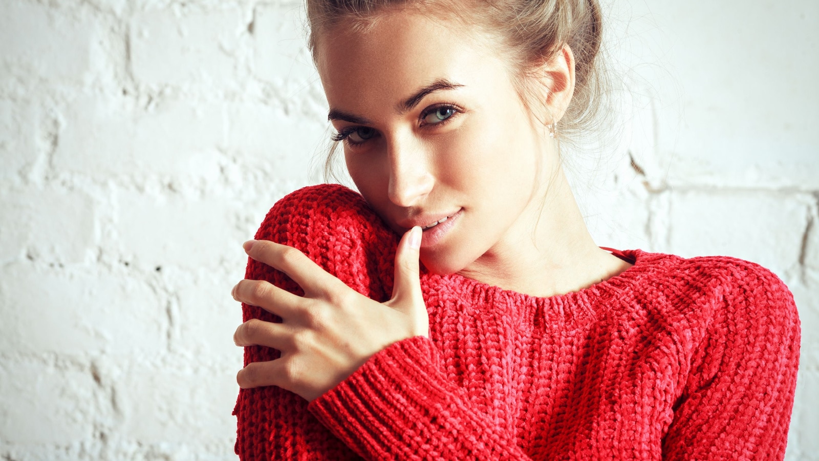 beautiful happy smiling blonde woman girl in warm red sweater. Glamour style portrait