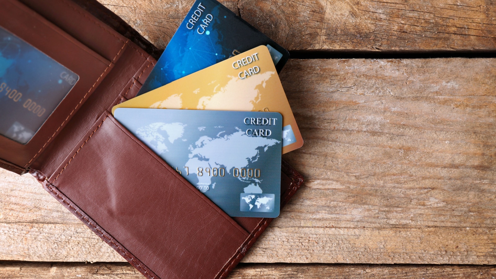 Credit cards in leather wallet on wooden background