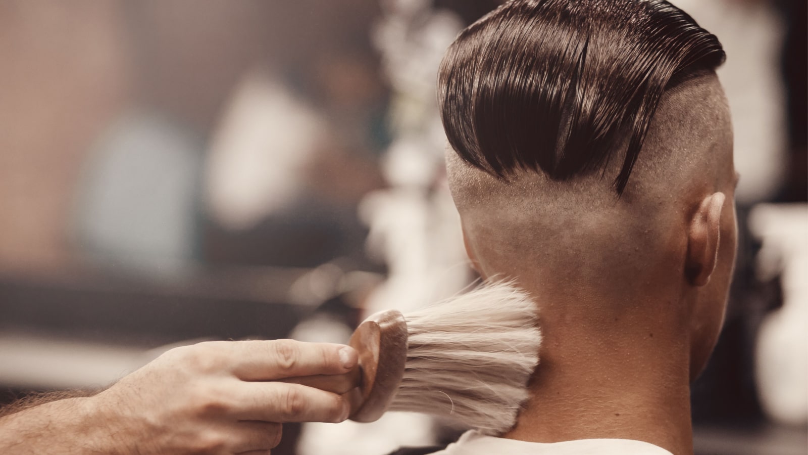 Close-up of barber shop does haircut undercut for man. Concept barbershop. Soft focus.