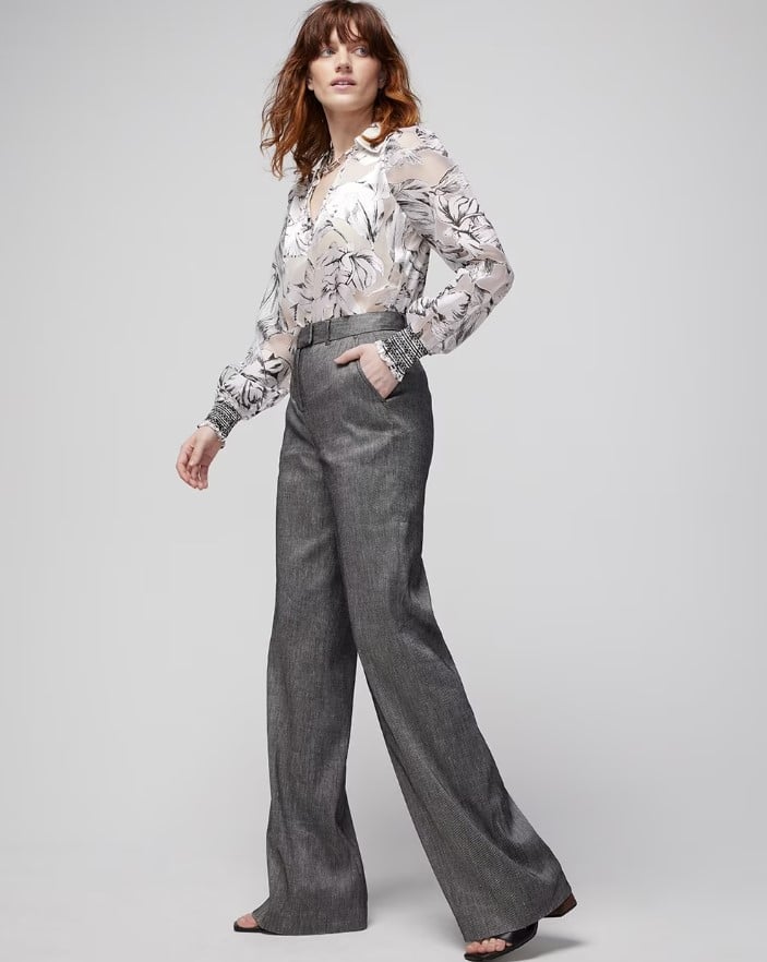 Woman modeling white house black market outfit grey trousers and white and grey floral blouse