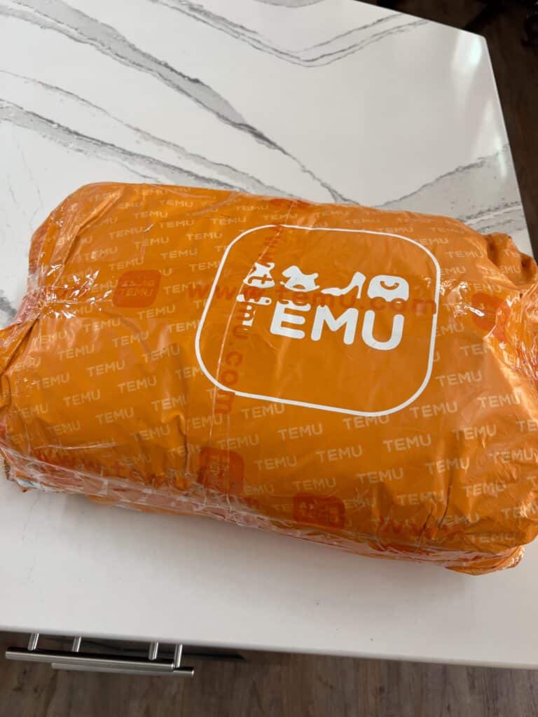Temu's orange package sitting on a white countertop