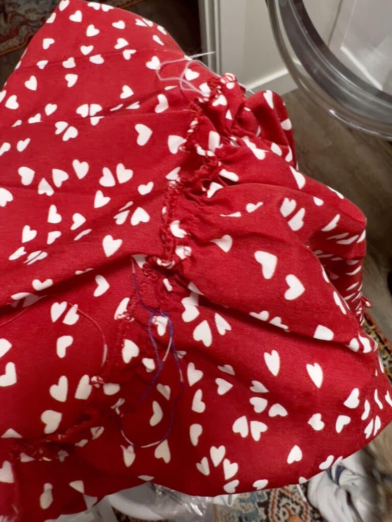 Red Temu dress with white hearts showing poor stitching and loose threads