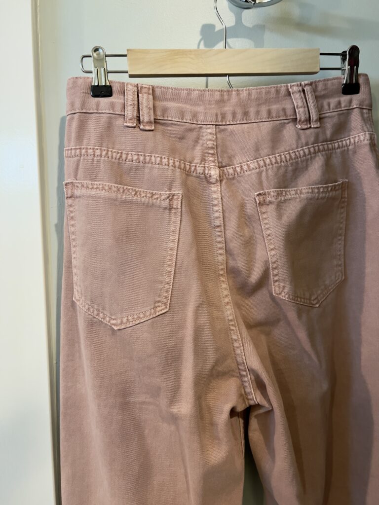 Chicwish pink jeans hanging on a hanger