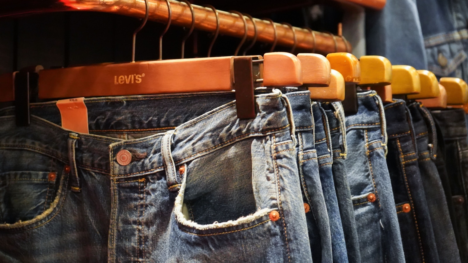 Bangkok, Thailand - August 10, 2018 : Levi's blue jeans hang on a shelf in A Levi’s Store. Levi Strauss is one of the world's oldest and most well known jeans manufacturers.