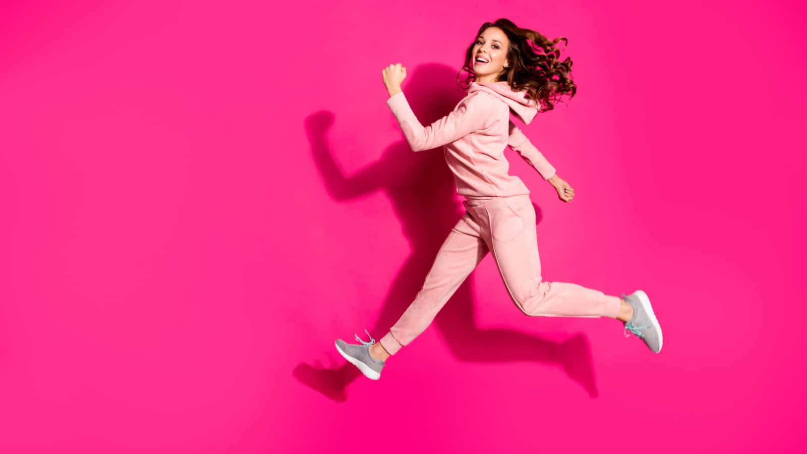 Full length body size photo jump high amazing party lady hands arms fists raised great flexibility wearing casual pink costume suit pullover outfit isolated bright vibrant rose background