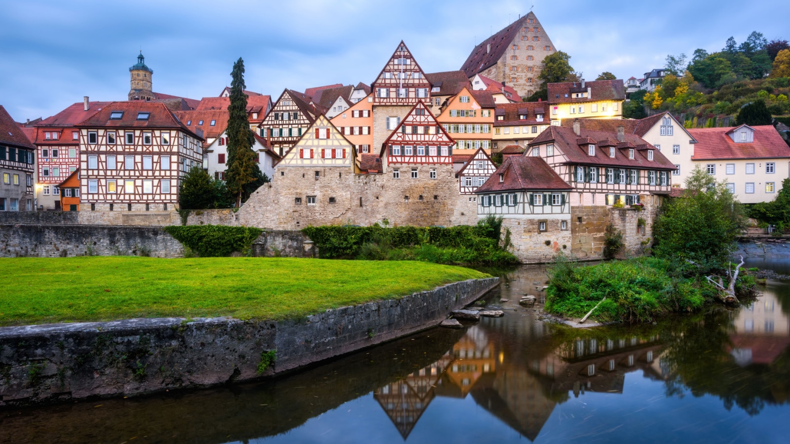 Gothic half-timbered houses reflecting in blue river in the Schwabisch Hall city Old town, Germany