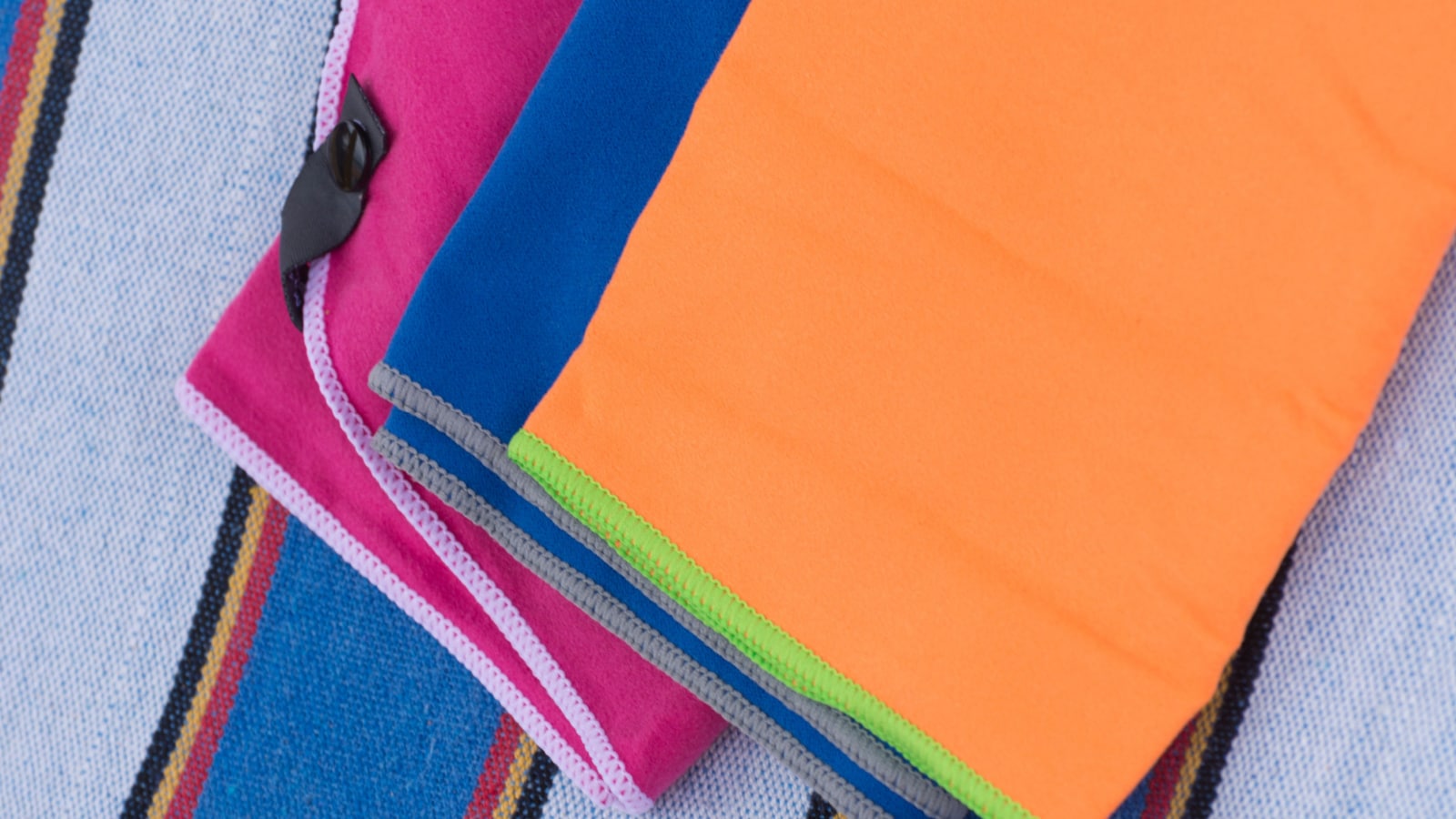 Microfiber towels on a beach lounger, outdoor activity concept. Background of multicolored towels close-up. Copy space.