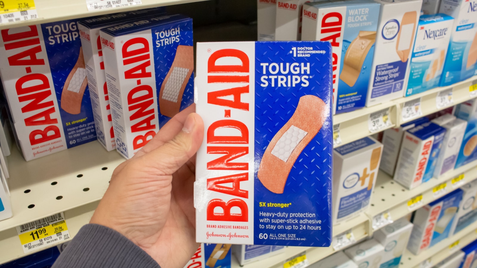 Los Angeles, California, United States - 02-01-2023: A view of a hand holding a package of Band-Aid bandages, on display at a local grocery store.