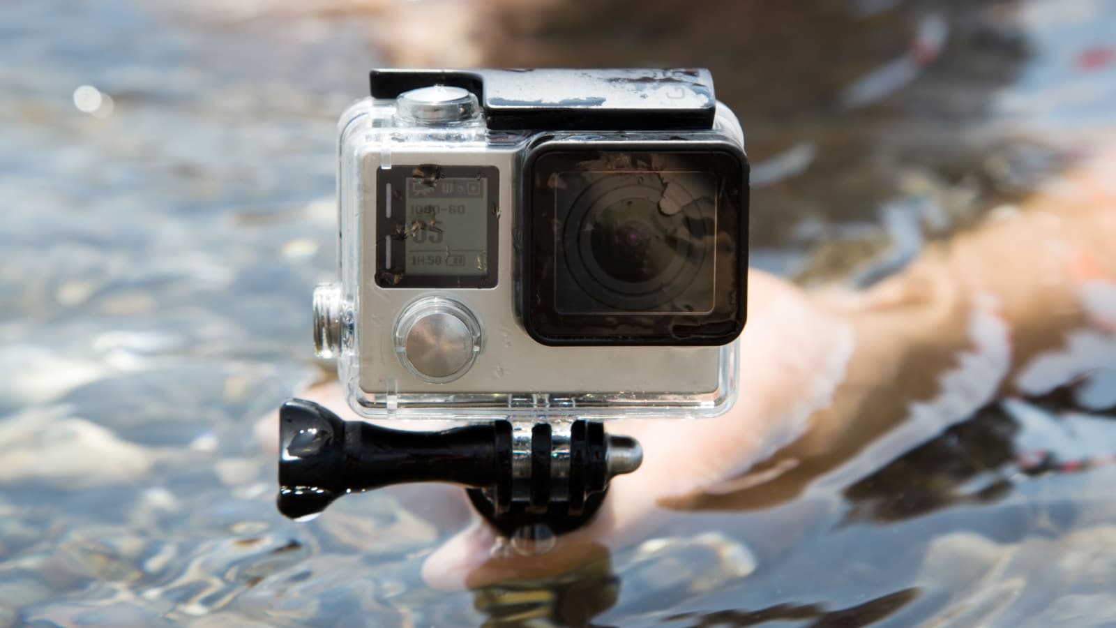 Hands on water with camera GoPro
