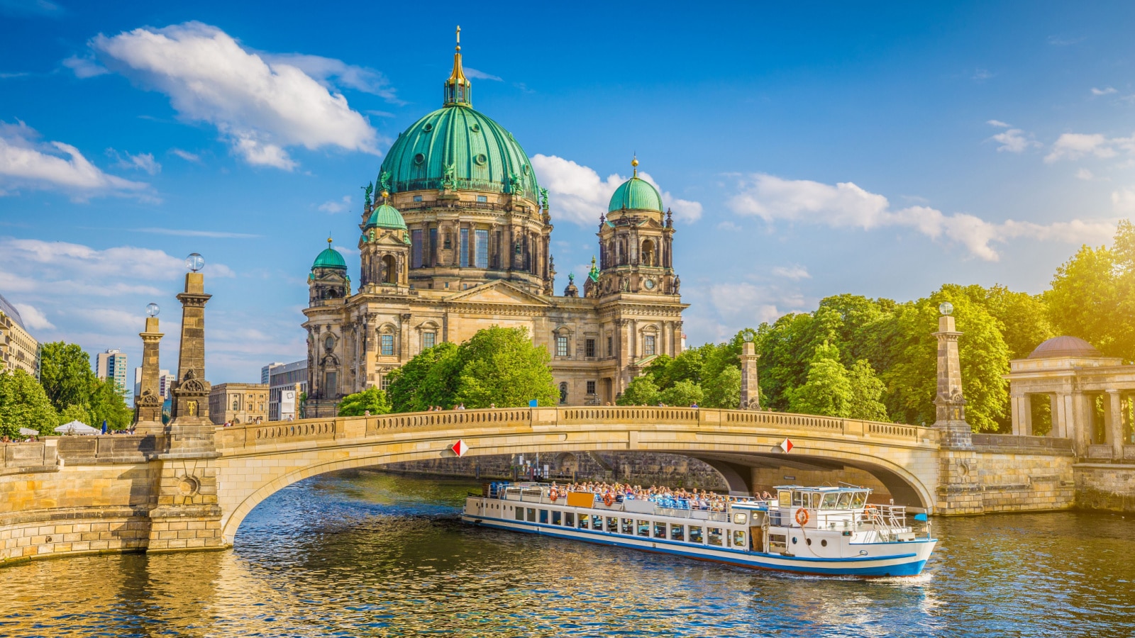 A beautiful view of historic Berlin Cathedral (Berliner Dom) at famous Museumsinsel (Museum Island) with an excursion boat on the Spree river in Berlin, Germany.