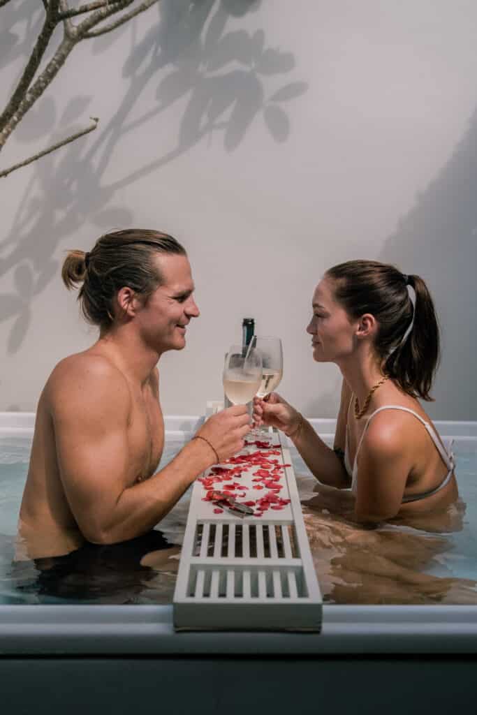 Travel influencers toasting in a bathtub at a resort in Thailand