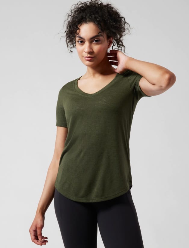 A green BREEZY SCOOP V TEE by Athleta paired with black leggings