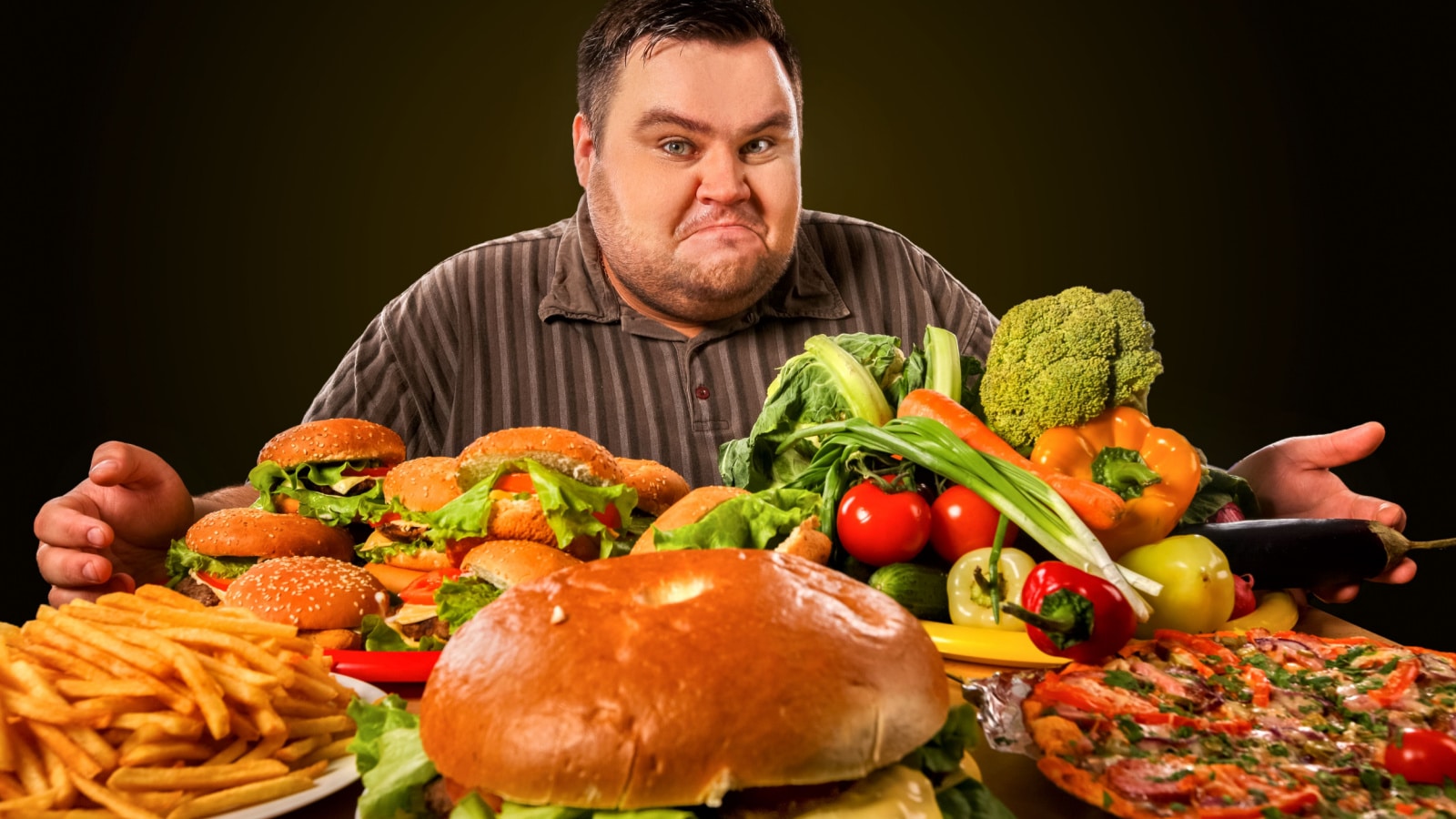 Diet fat man who makes choice between healthy and unhealthy food . Overweight male with hamburgers, french fries. Feast on the occasion of the feast.
