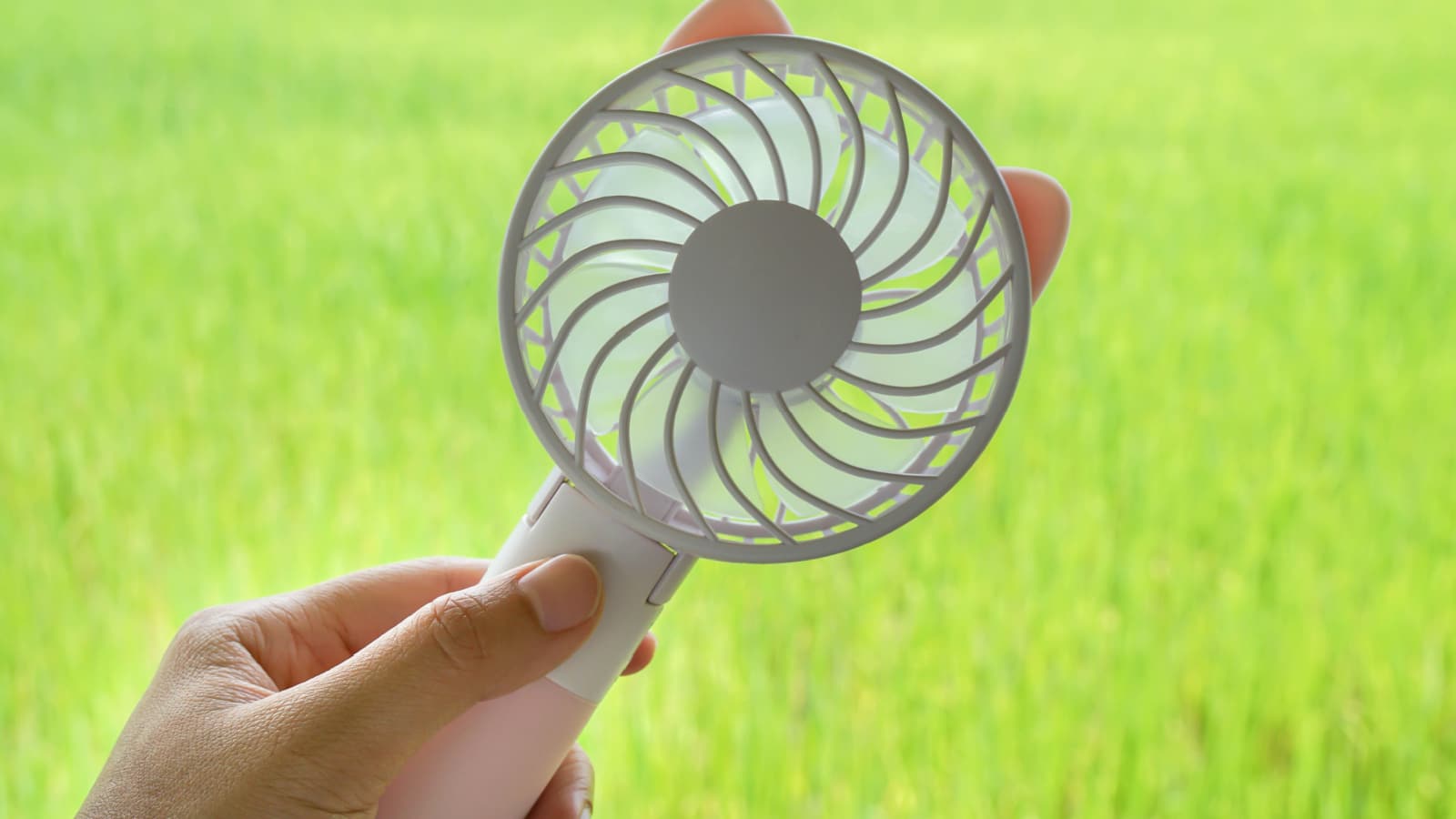 close up woman hold portable motor USB fan for outdoors travel