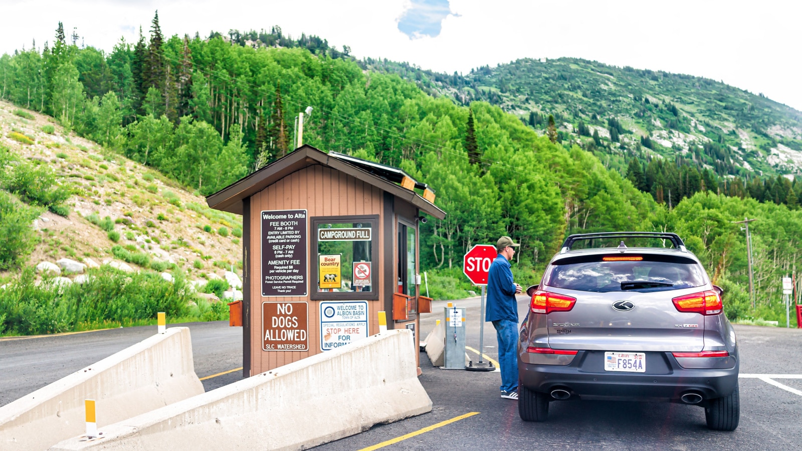Alta, USA - July 25, 2019: Entrance with information sign to national park hiking trails in Albion Basin, Utah summer in Wasatch mountains and campground with man employee worker