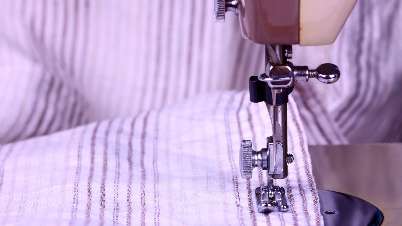 Striped cotton material and a vintage sewing machine in close up