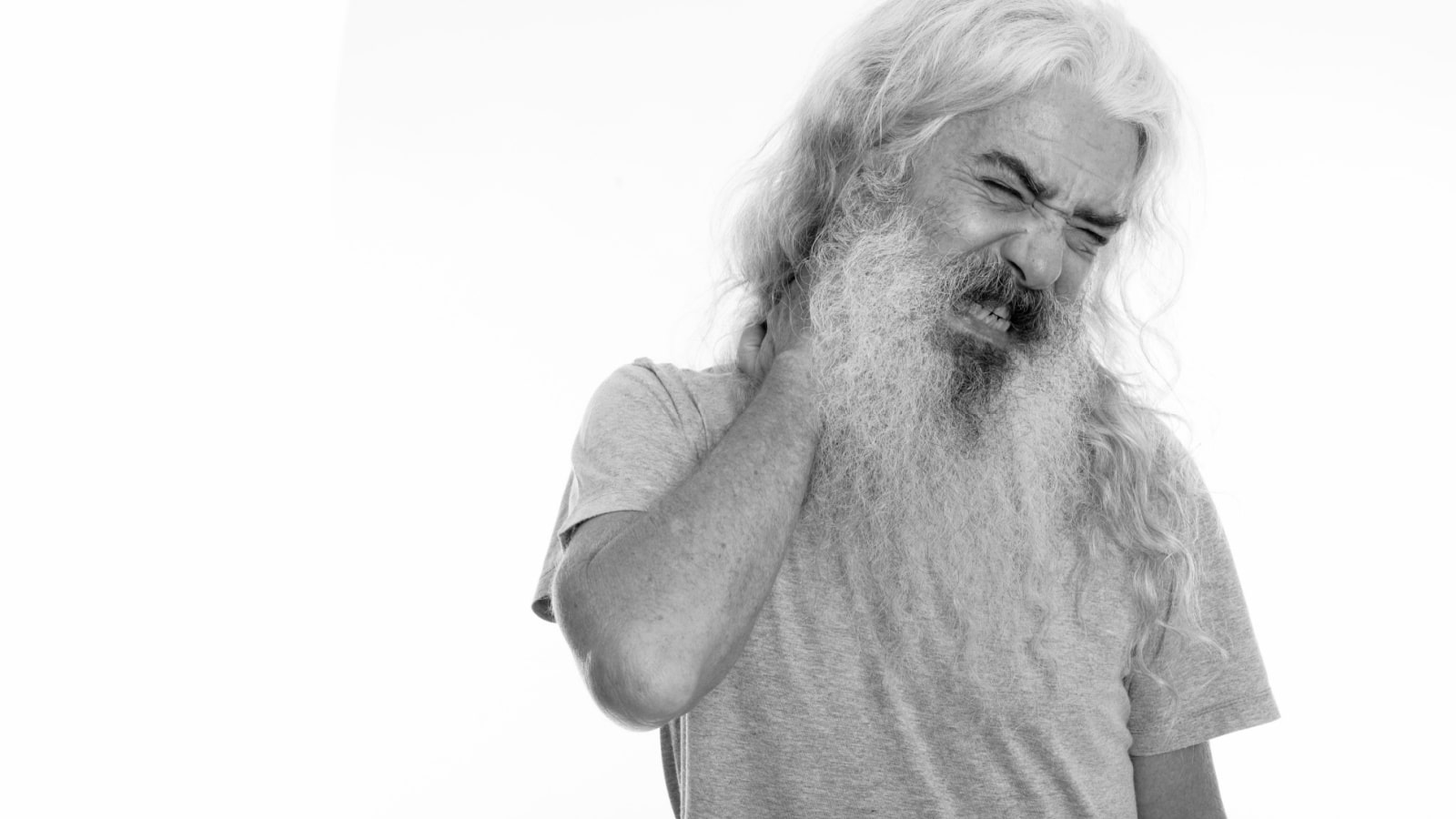 Studio shot of senior bearded man isolated against white background in black and white