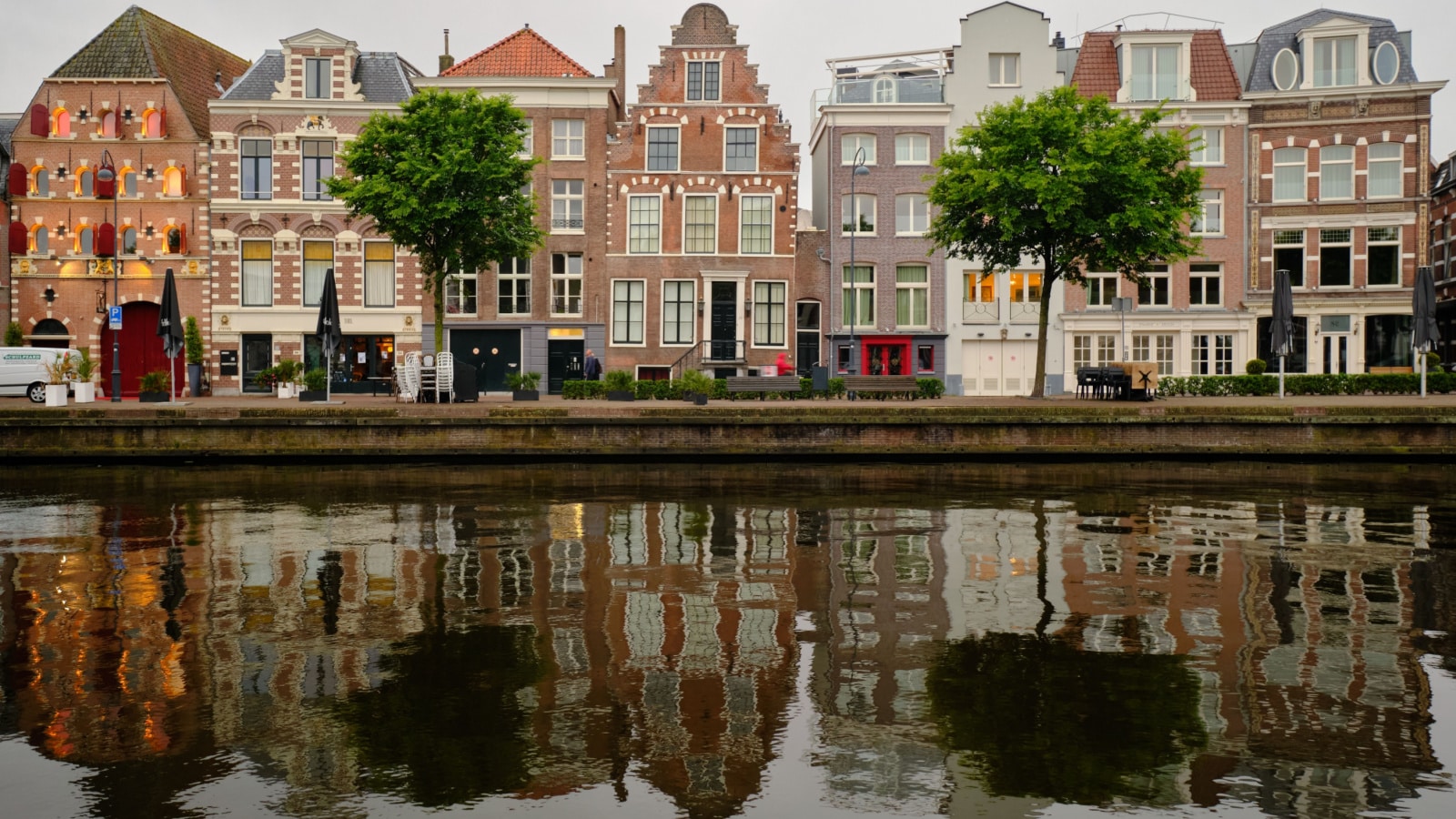 Haarlem, Netherlands - May 23. 2022: Panoramic view of traditional Dutch houses in a row lining the river Sparne in the summer.