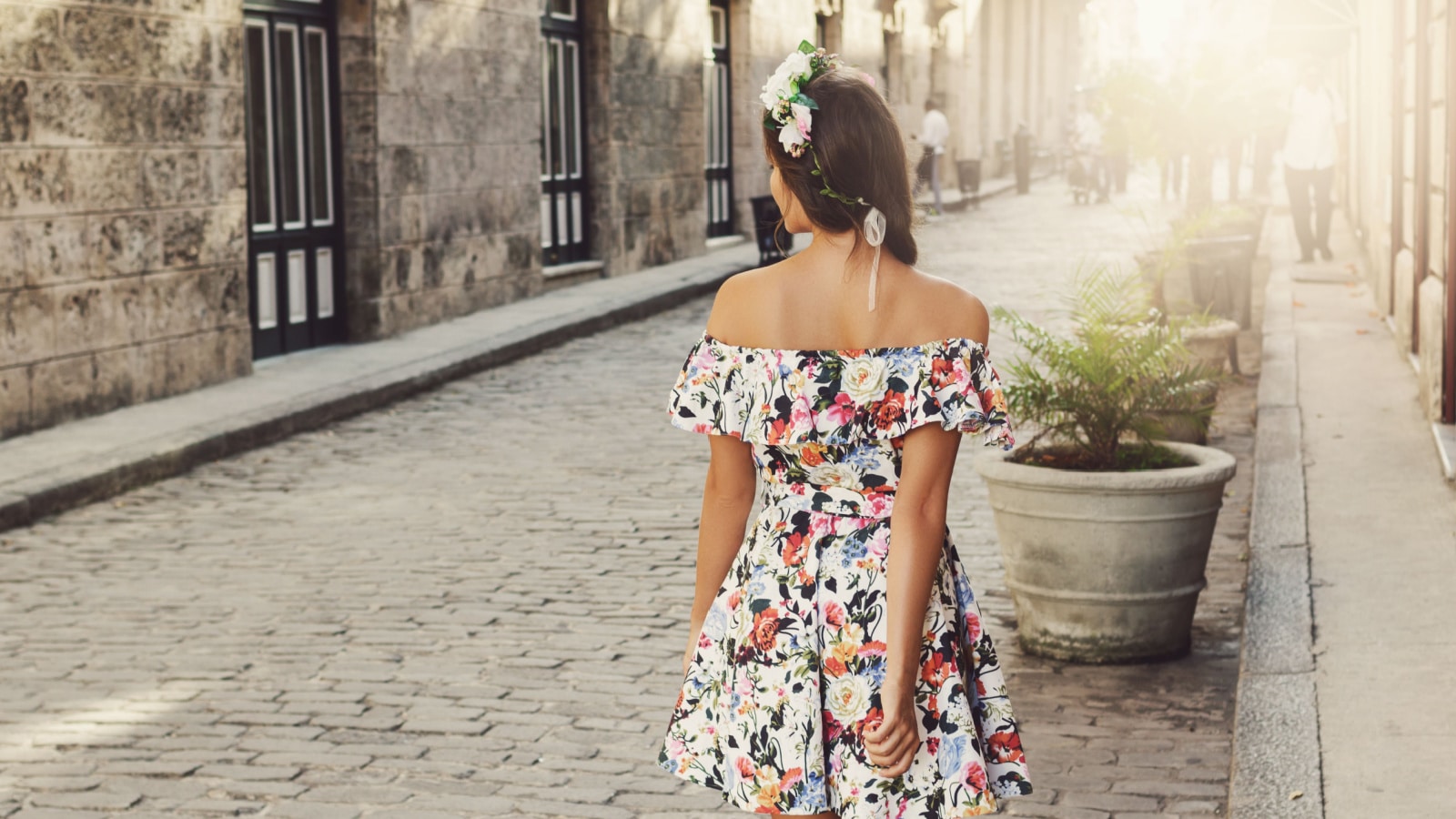 Happy woman in beautiful floral dress on the street of Havana city