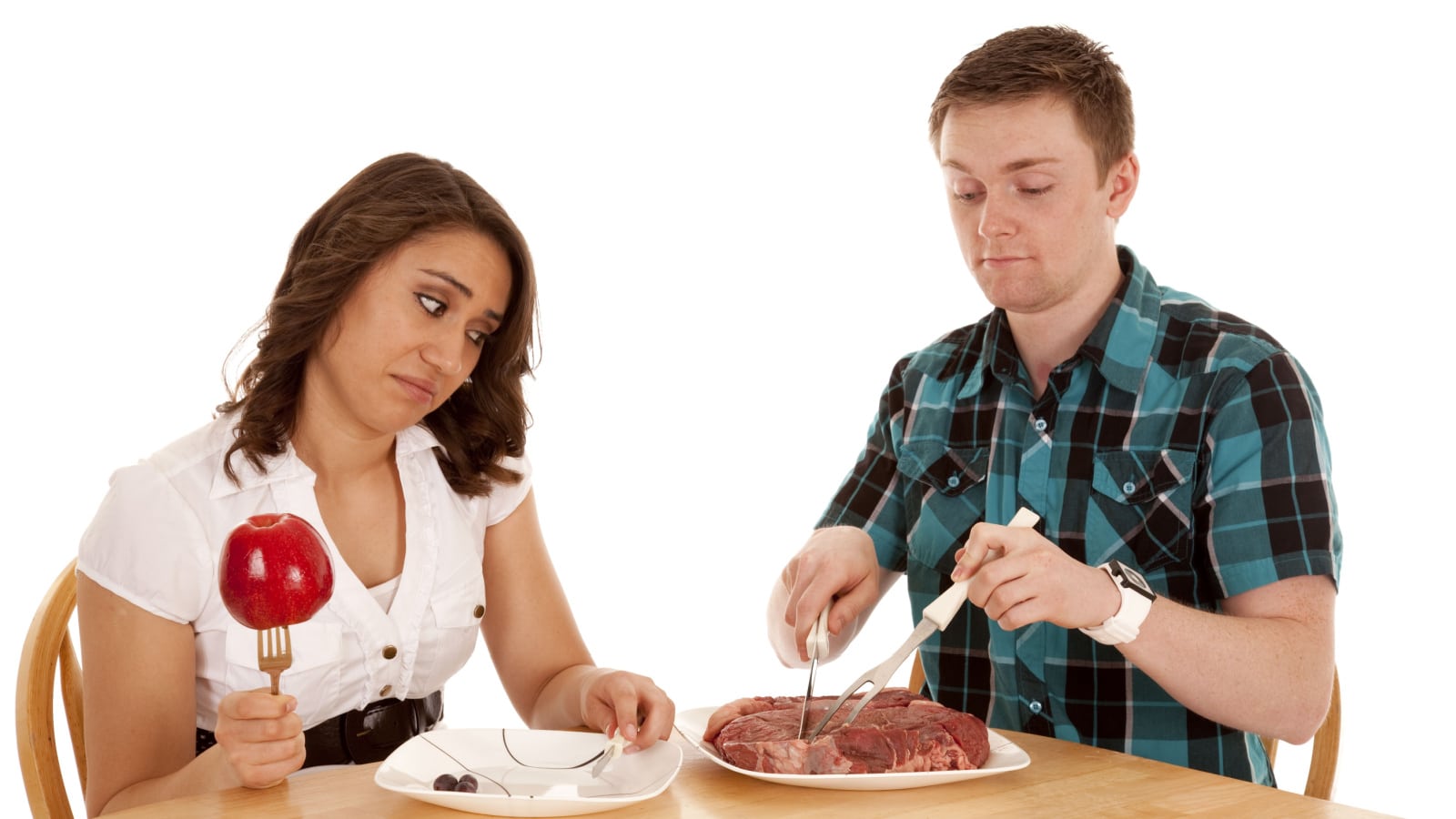 a woman with fruit stuck on her fork looking at her dates steak