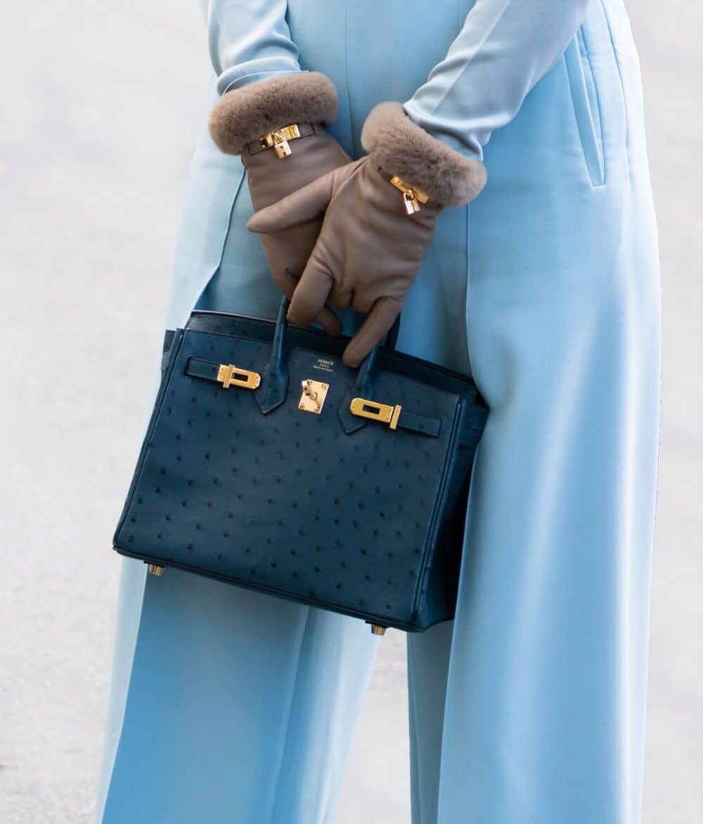 Paris, France - October, 1, 2022: woman wearing navy blue ostrich leather Birkin handbag from Hermes, street style outfit details.