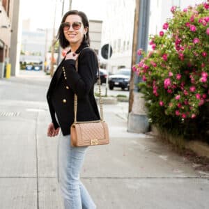 Lindsey of Have Clothes, Will Travel showing a pink Chanel boy bag paired with a black blazer and jeans