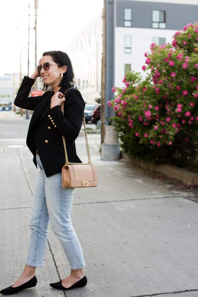 Lindsey of Have Clothes, Will Travel showing a pink Chanel boy bag paired with a black blazer and jeans