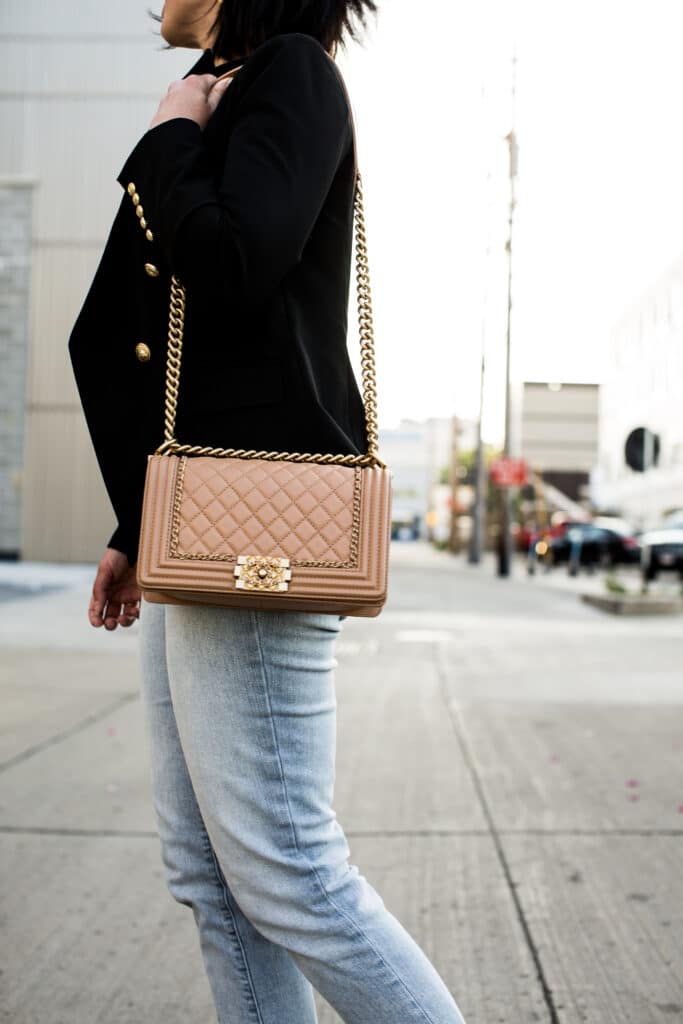 Lindsey of Have Clothes, Will Travel showing a pink Chanel boy bag paired with a black blazer and jeans