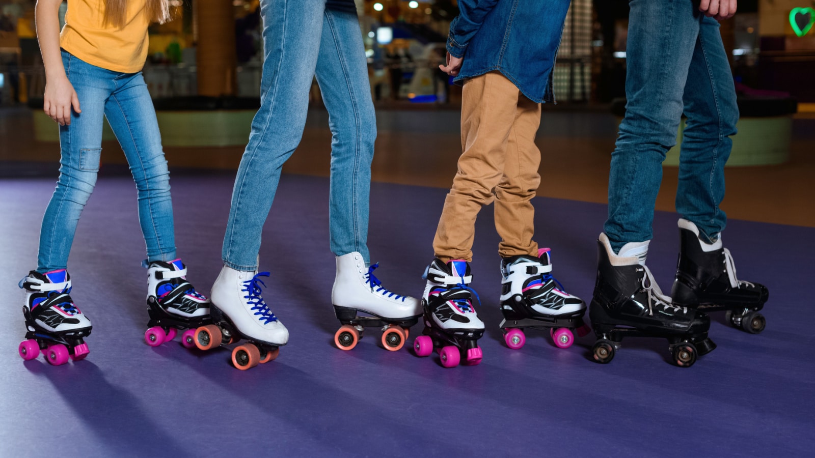 partial view of parents and kids skating on roller rink together