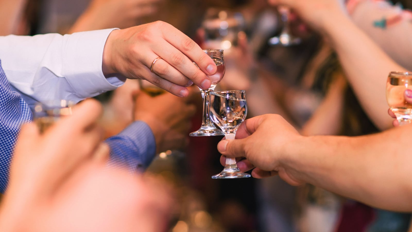 hands with glasses of vodka celebrating the traditional Russian holiday