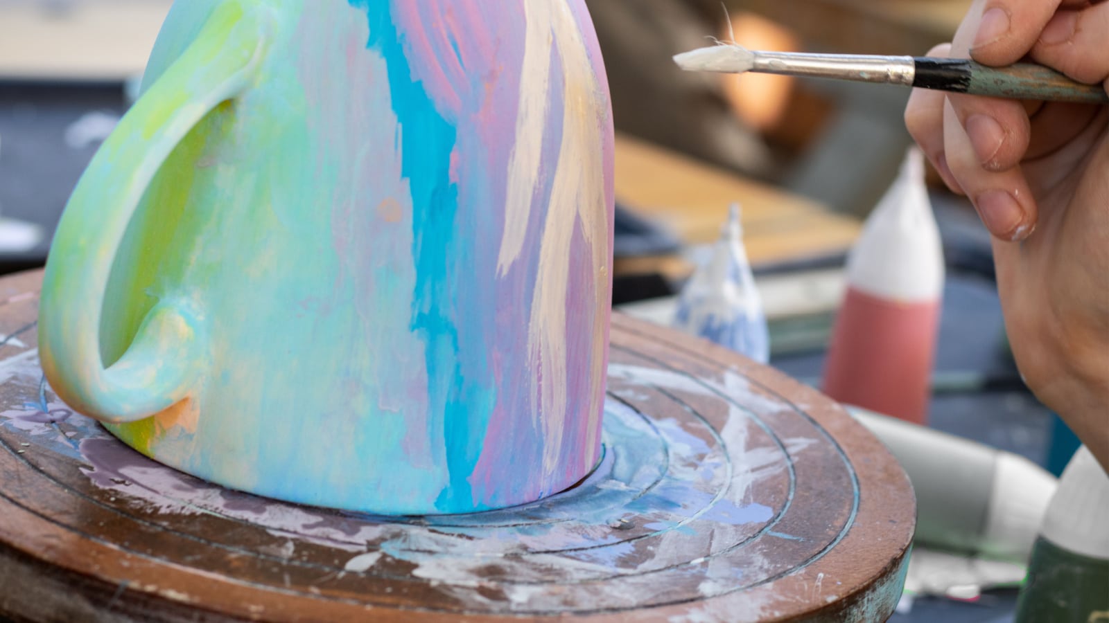 Hand painting a ceramic mug