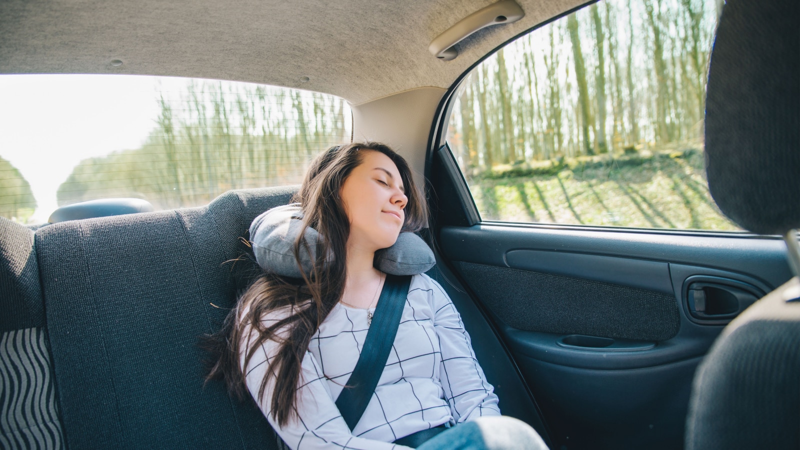 woman at car backseats fasten with belt sleeping. car travel concept