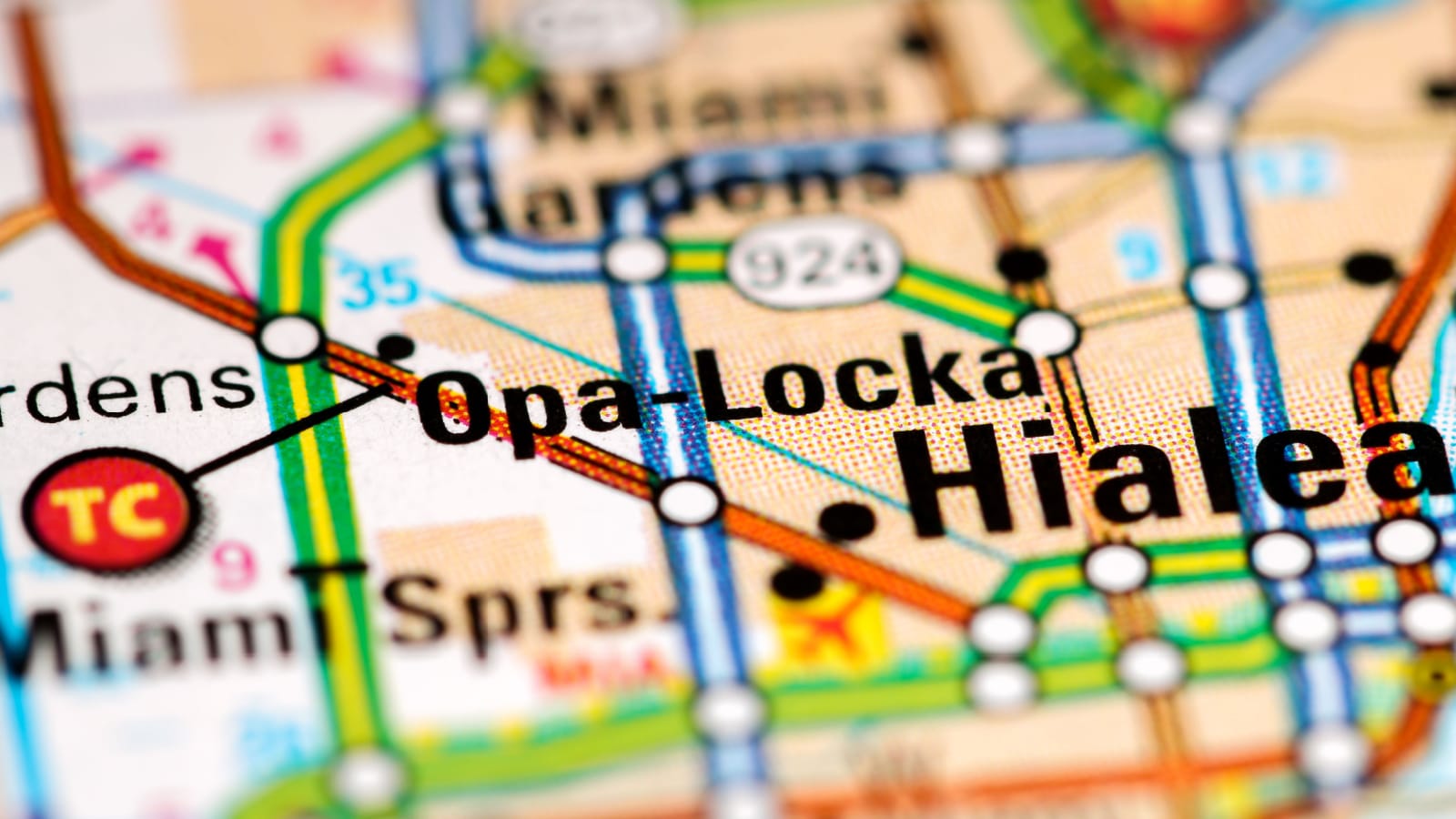 A closeup image of a paper map, showing Opa-Locka, Florida's location amid colorful pathways.