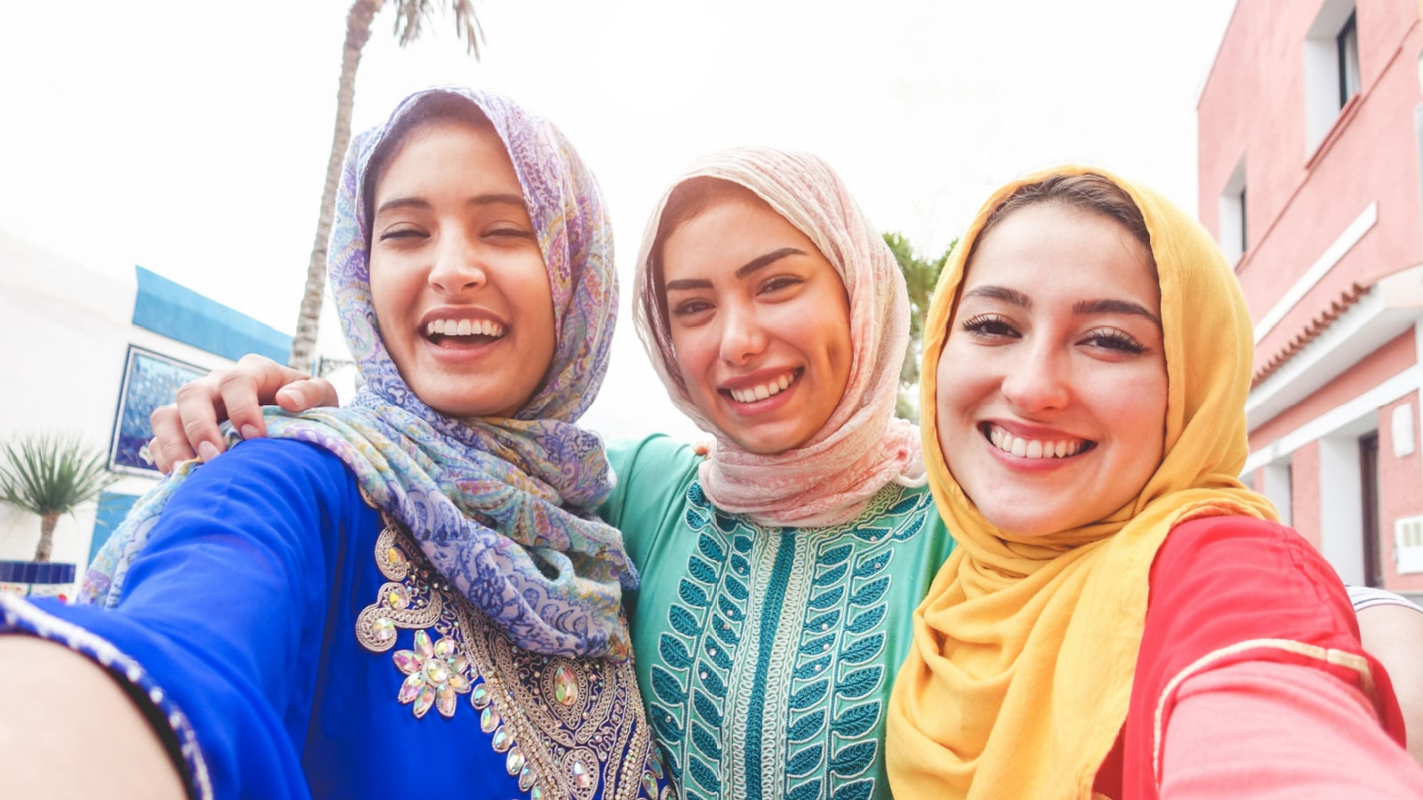 Islamic young friends taking selfie with smartphone camera outdoor - Happy arabian girls having fun with new trend technology - Friendship and millennial app concept - Focus on faces