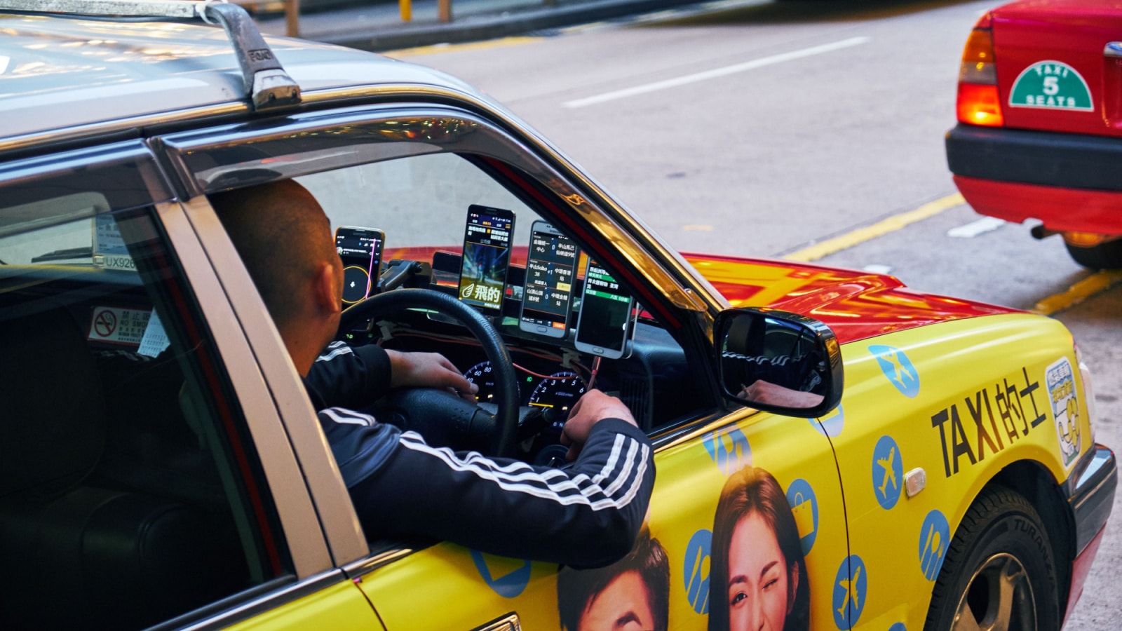 HONG KONG - JANUARY 2, 2019: Taxi driver with four smartphones