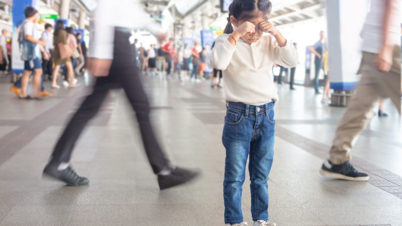 asian kid crying to lost parent or live alone on sky train station in Bangkok city,Thailand