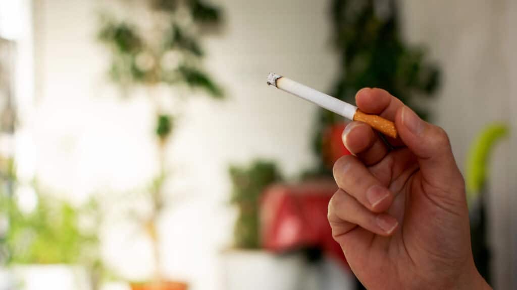 Hand holding a cigarette close up. Smoking concept.