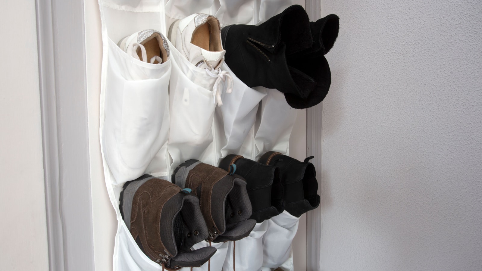 Shoe rack hanging on a wooden door, storage for shoes close-up