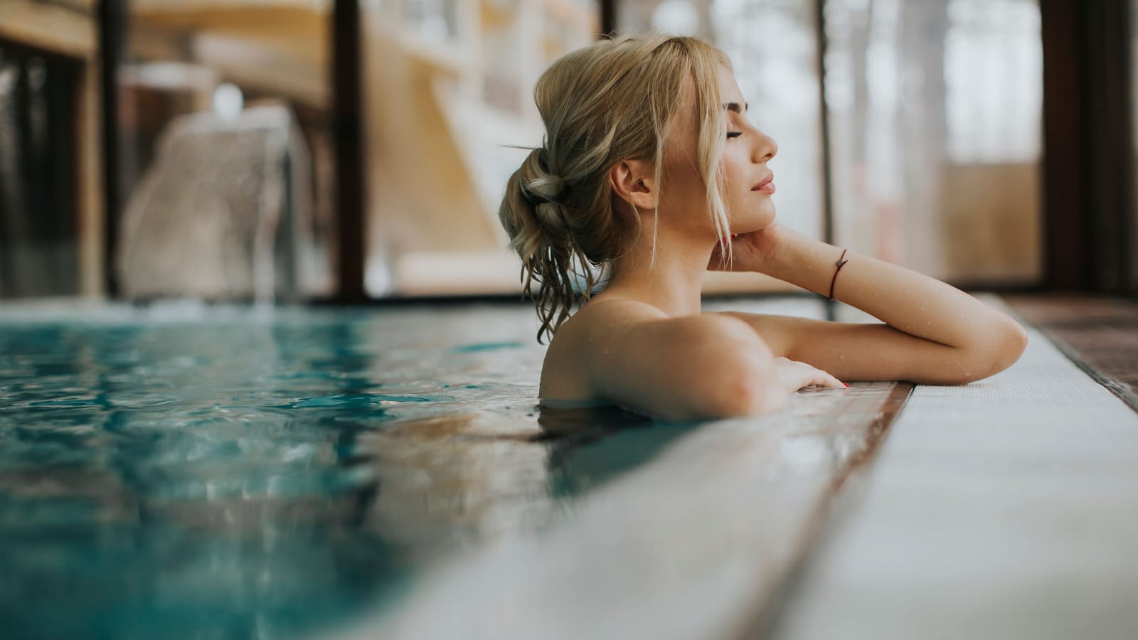 Sensual young woman relaxing in spa swimming pool