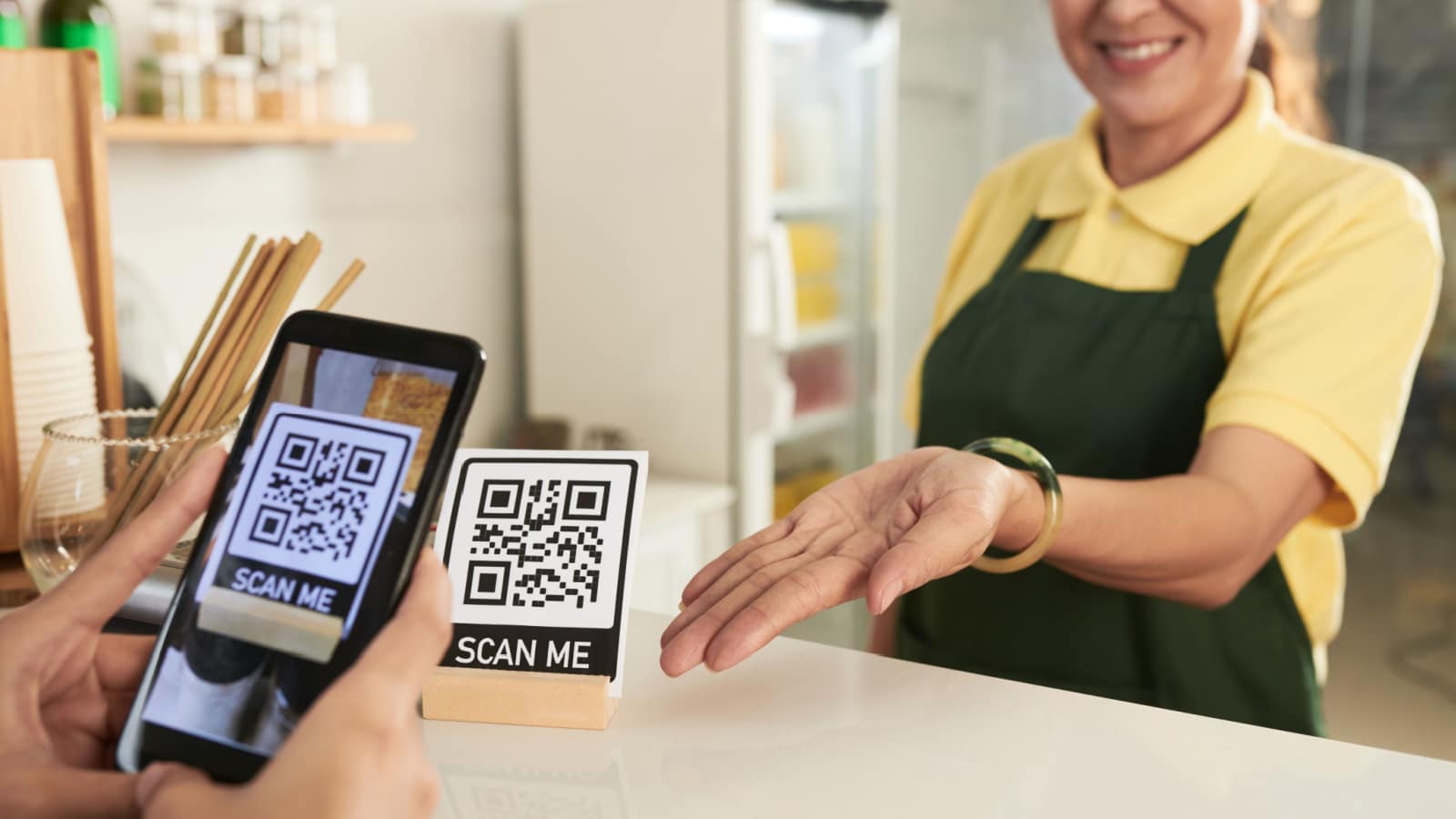 Closeup image of customer scanning QR code in cafe to downloadu