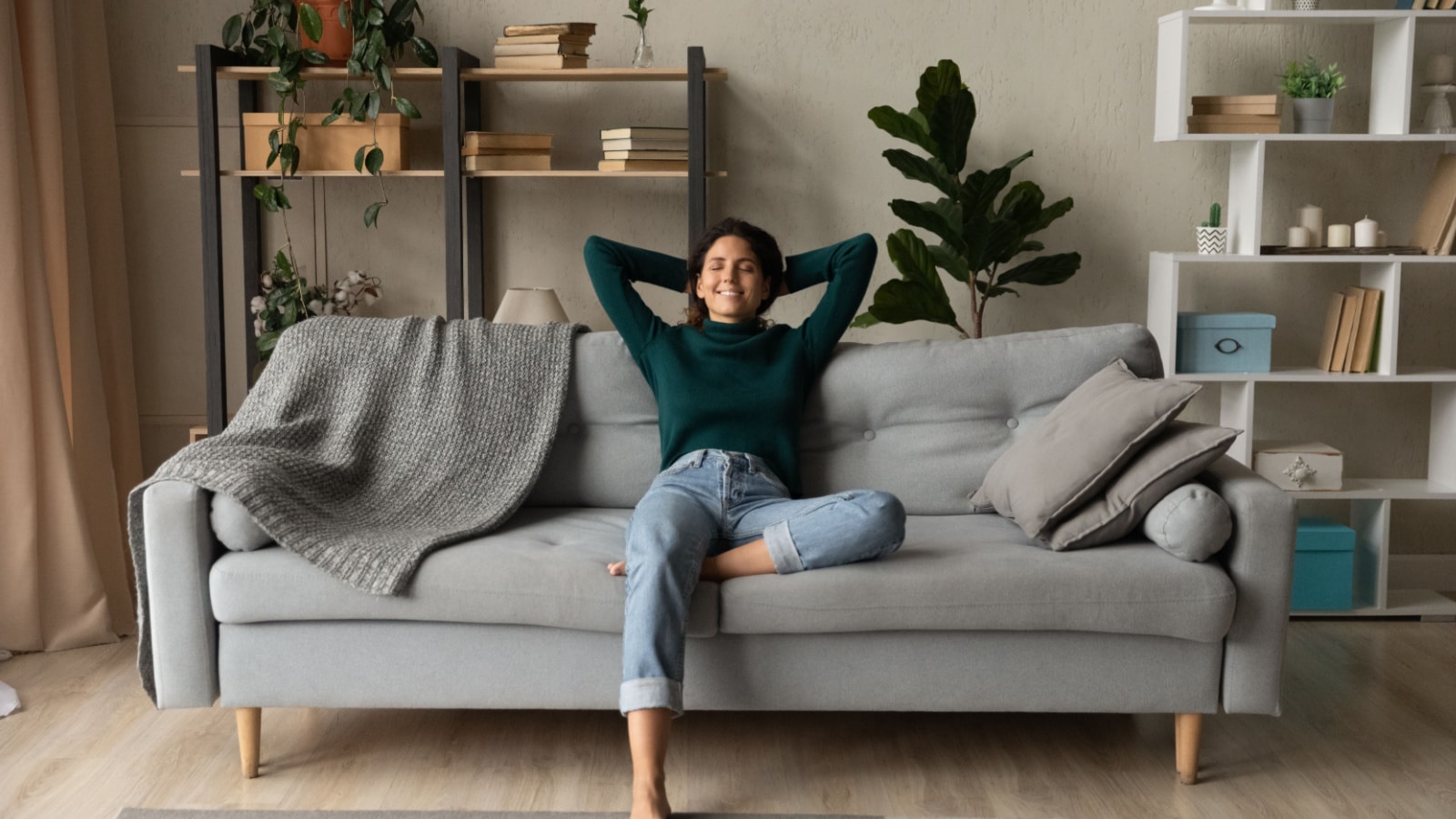 Sweet idleness. Lazy young hispanic lady sit in relaxed pose on big comfy sofa at living room interior breath air dream imagine. Successful female new flat apartment buyer rest at home feel pleasure