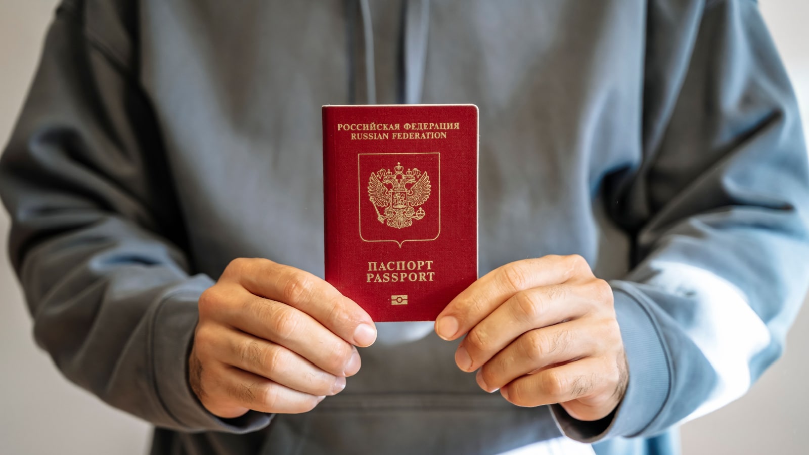 Russian passport in the hands of a man. Prohibition of Schengen visas for Russian tourists to travel to the European Union concept.