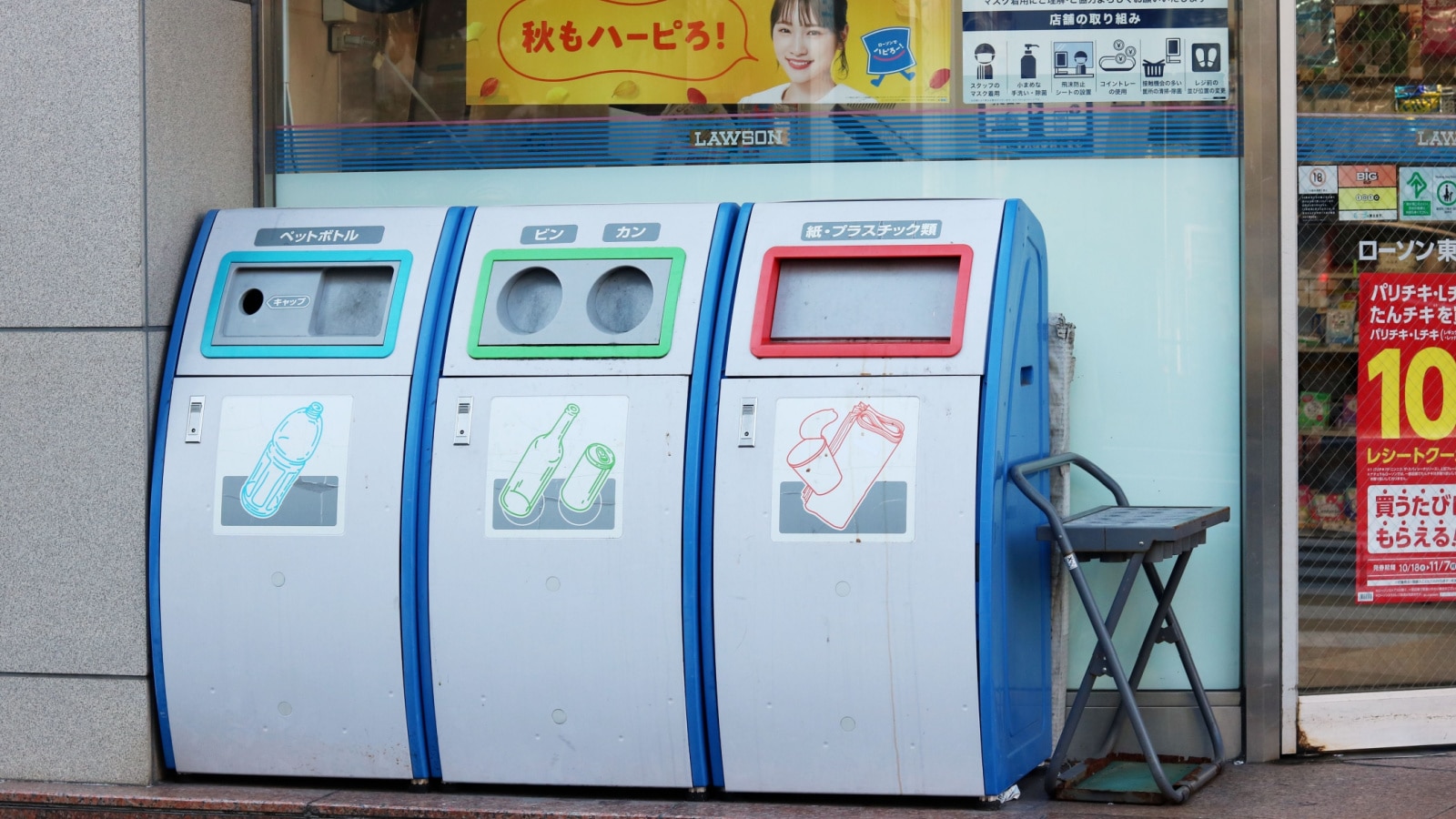 TOKYO, JAPAN - November 3, 2022: Waste containers for different kinds of trash (plastic bottles; bottles and cans; paper and plastic) outside a Lawson convenience store in Tokyo's Koto Ward.