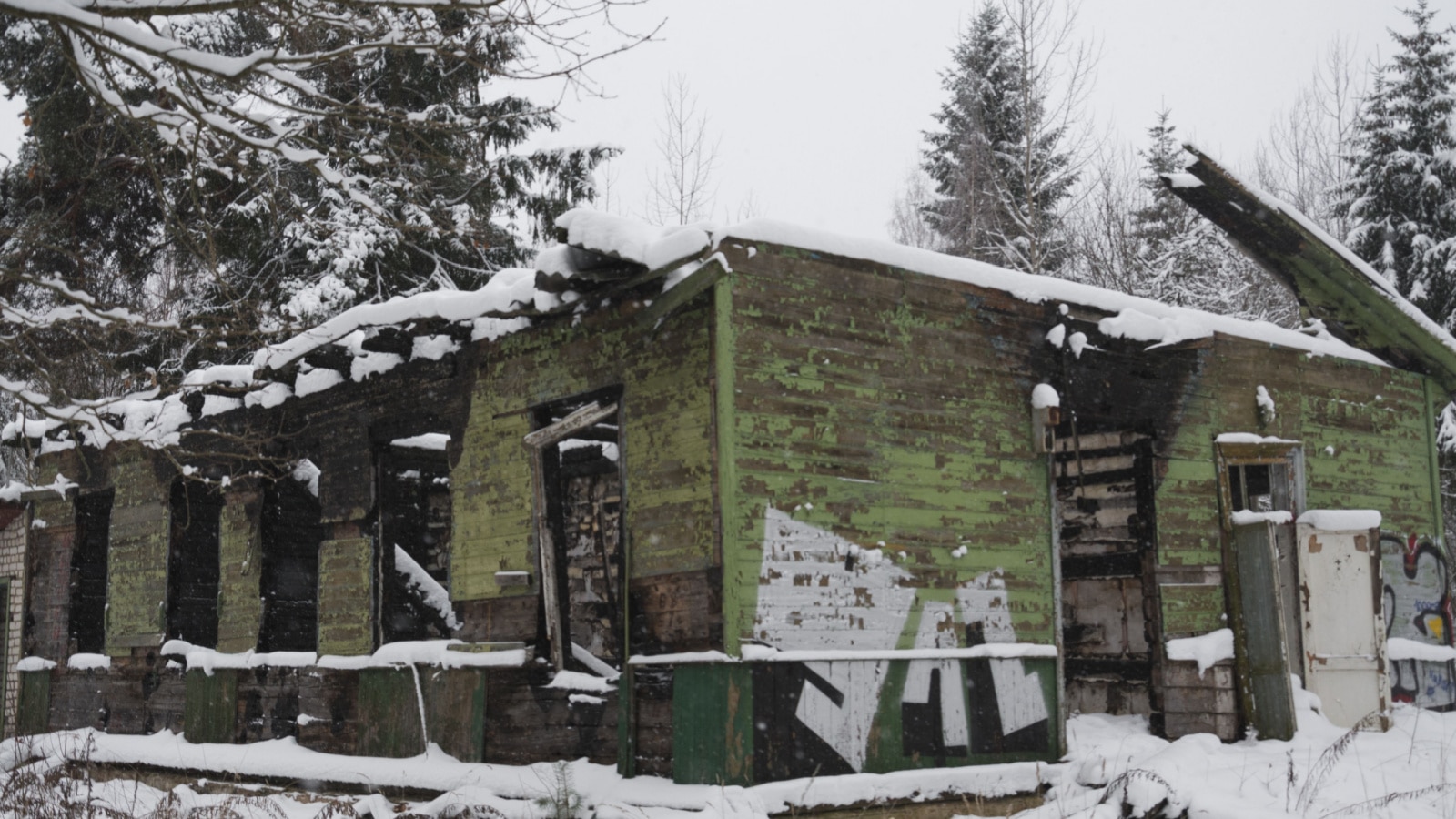 an old abandoned building in winter in the woods