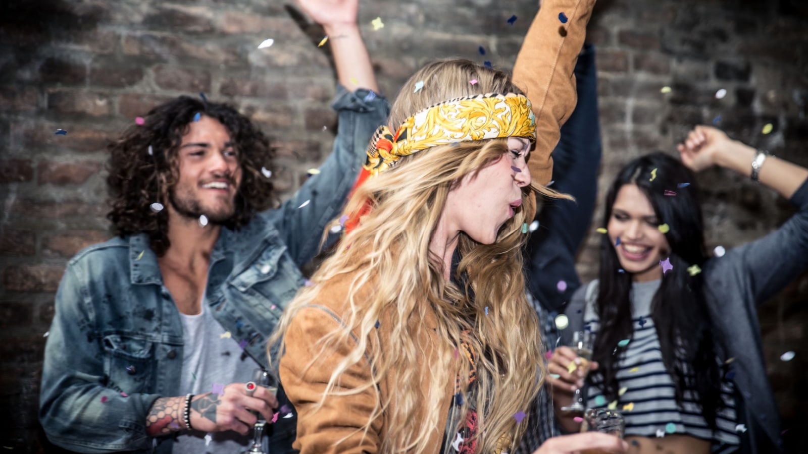 Group of young adults hanging around in a disco club dancing partying
