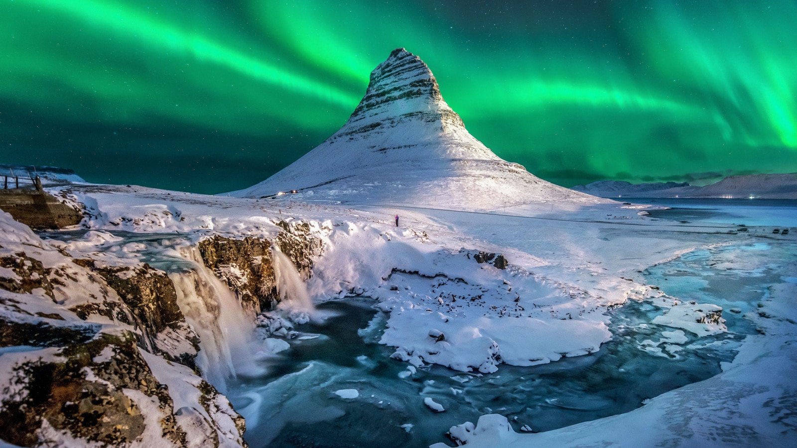 northern lights appear over Mount Kirkjufell in Iceland.