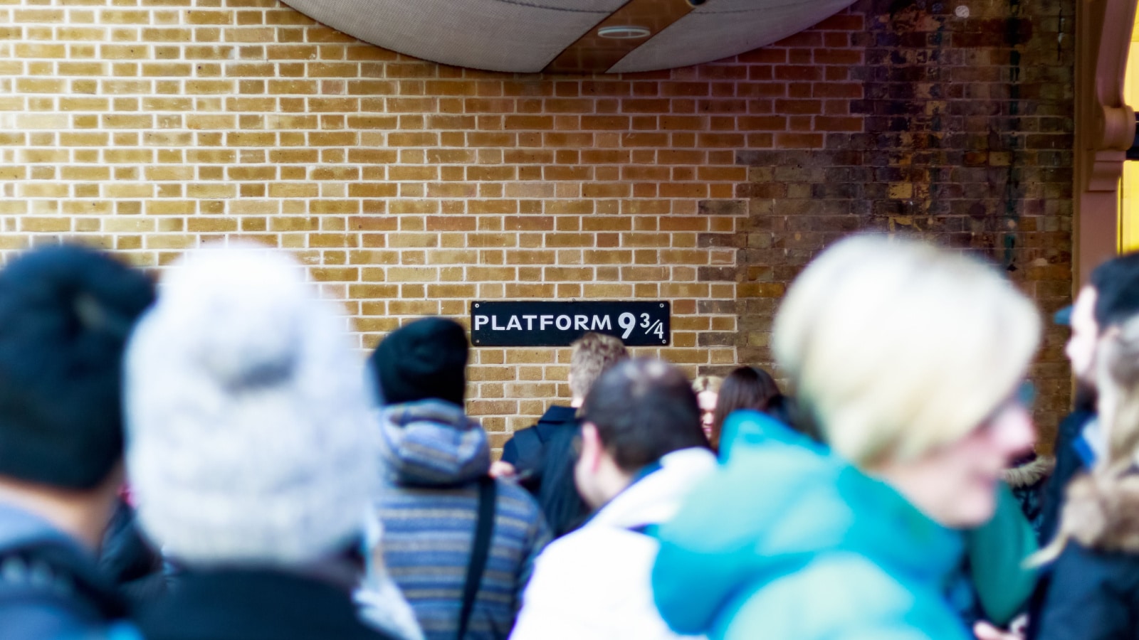 London, UK - February 28, 2017 - Platform 9 3/4 from Harry Potter at King's Cross station seen through queuing crowd