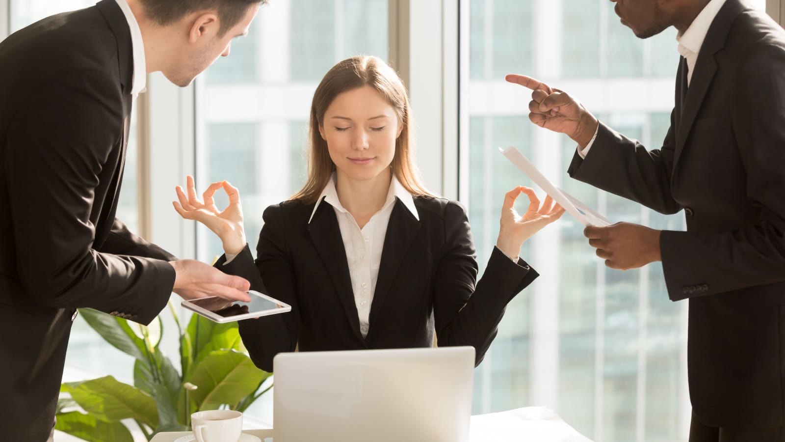 Beautiful businesswoman meditating at workplace, ignoring work, not listening to annoying clients or bothering colleagues talking to her, sitting at office desk with eyes closed, keep calm, no stress