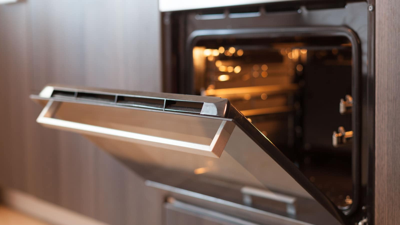 Empty open electric oven with hot air ventilation. New oven. Door is open and light is on