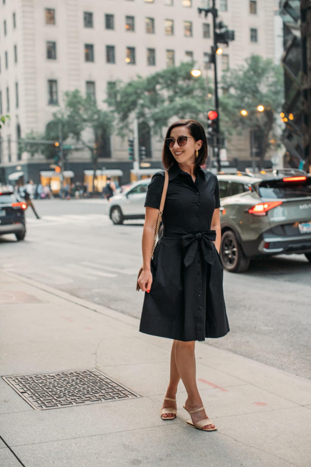 Lindsey of Have Clothes, Will Travel wearing Frances Valentine black Bella Dress standing on the street in Chicago with one hand in pocket